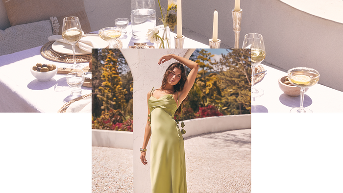 Woman wearing a sage green satin cowl neck maxi dress at an outdoor summer wedding