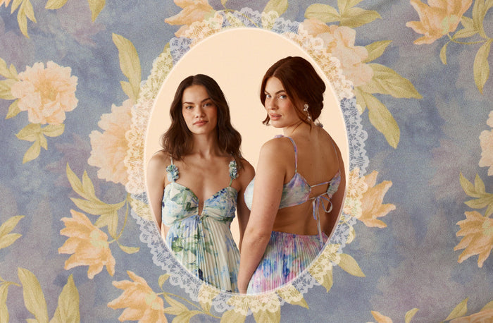 Two women model pastel floral dresses, showing front and open-back views within a lace-trimmed oval on a blue floral background.