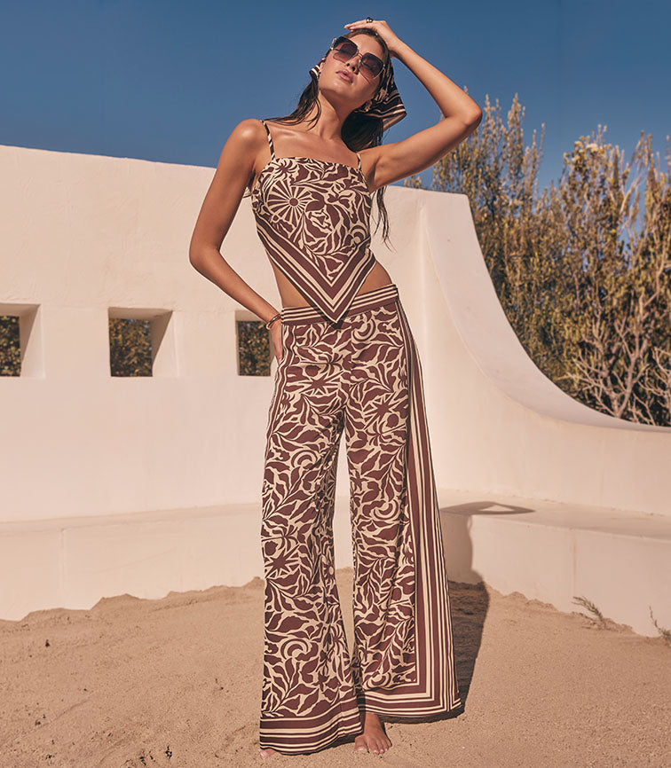Woman wearing a brown and tan patterned sleeveless top and wide-leg pants with matching design.