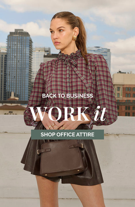 Woman wearing a plaid blouse with a bow tie and a leather skirt, holding a brown handbag.