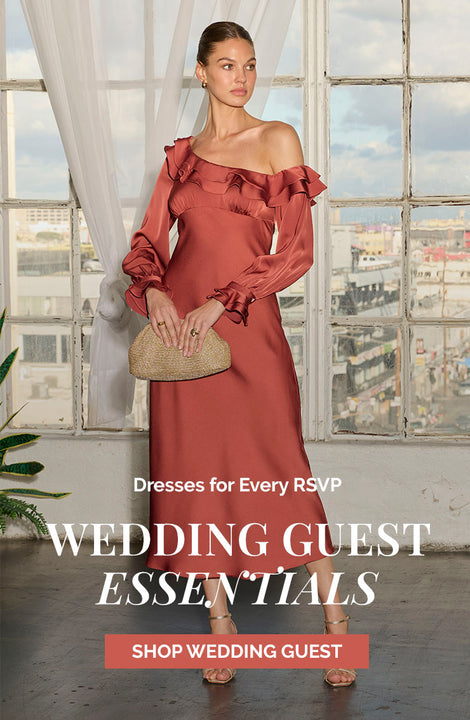 Woman in a rust-colored, off-the-shoulder, ruffled long dress holding a beige clutch.