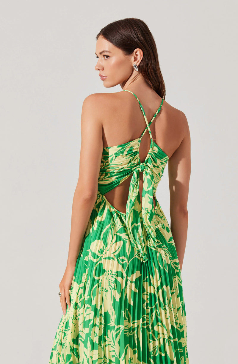Woman in a green and yellow floral dress with spaghetti straps, open back, and side cutouts.