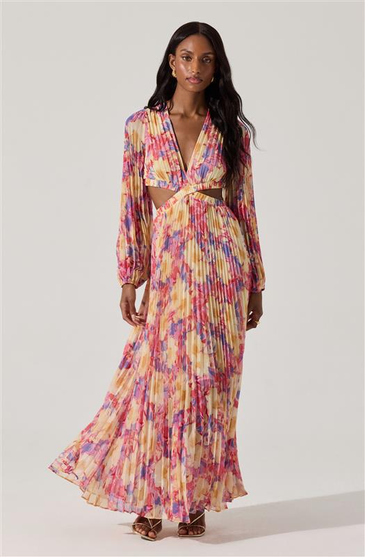 The dress features a colorful abstract print with shades of pink, purple, yellow, and cream. It has a deep V-neckline, long puff sleeves with elastic cuffs, and cut-out sections at the waist connecting the top and the skirt. The skirt is long, flowing, and pleated, extending to the floor.