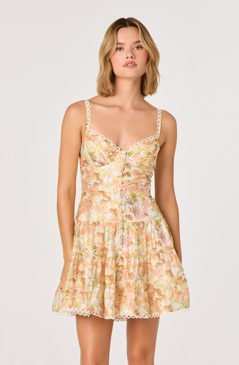 Woman in a sleeveless, floral-patterned sundress with lace trim and buttons down the front.