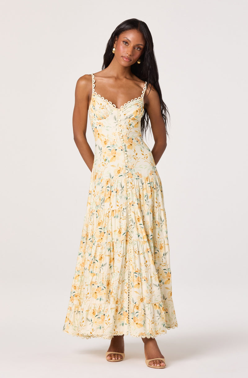 Sleeveless floral maxi dress with scalloped straps and button details.