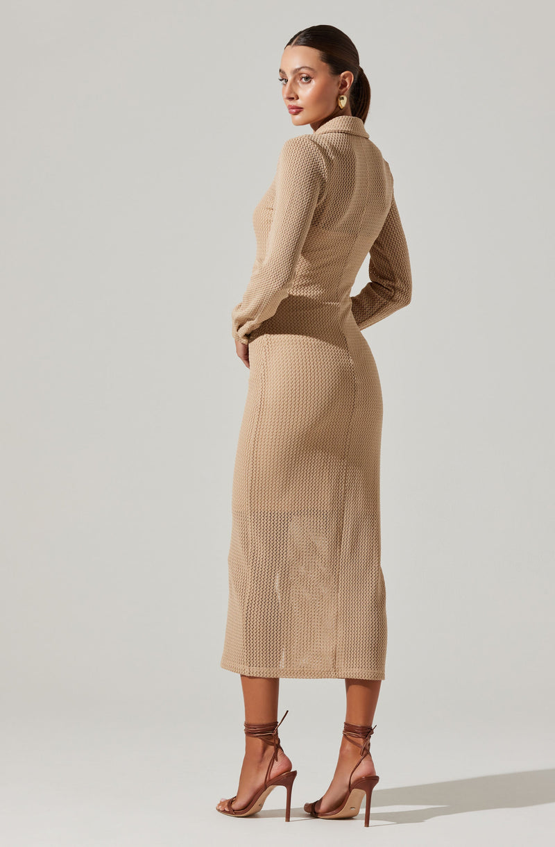 A woman is wearing a beige, textured knit long-sleeve top with a collar, paired with a matching high-waisted, knit midi skirt. She has on nude strappy high-heeled sandals that lace up around her ankles and gold hoop earrings.