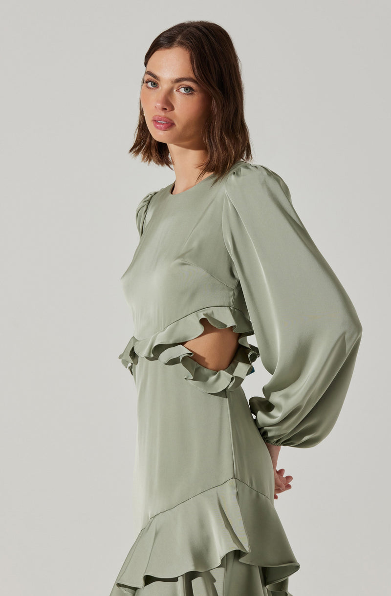 A woman is wearing a light green satin dress with long, puffed sleeves. The dress features ruffled details at the waist and hem, creating a layered, flowy appearance. The fabric appears smooth and glossy.