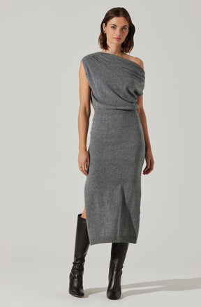 A woman is wearing a gray, sleeveless, off-the-shoulder dress made from a soft, knit fabric. The dress has a relaxed, draped bodice and a fitted waist, falling to a mid-calf length. She is also wearing tall black leather boots that reach just below the knees.