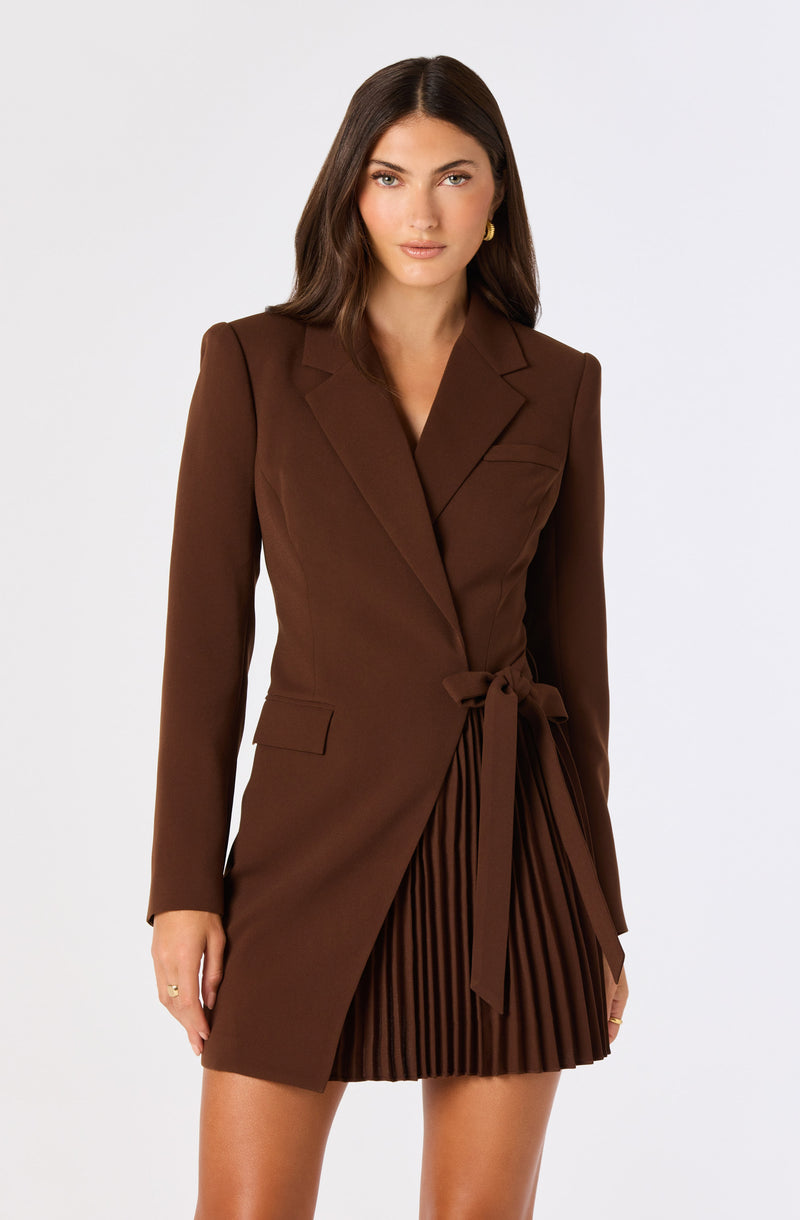 Brown blazer with a waist tie, paired with a pleated skirt.
