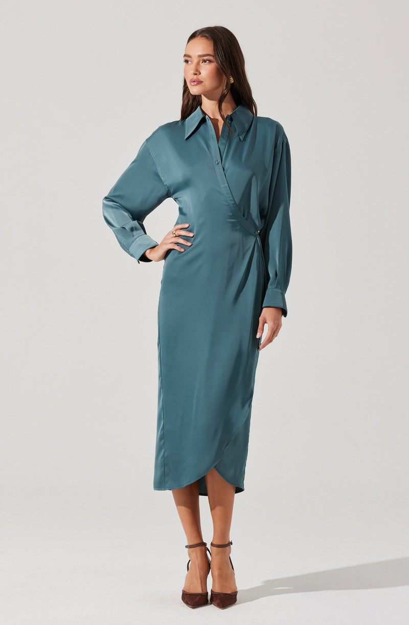 A woman is wearing a long, teal satin dress with a collar, long puff sleeves with cuffs, and a wrap-style skirt that falls below the knees.
