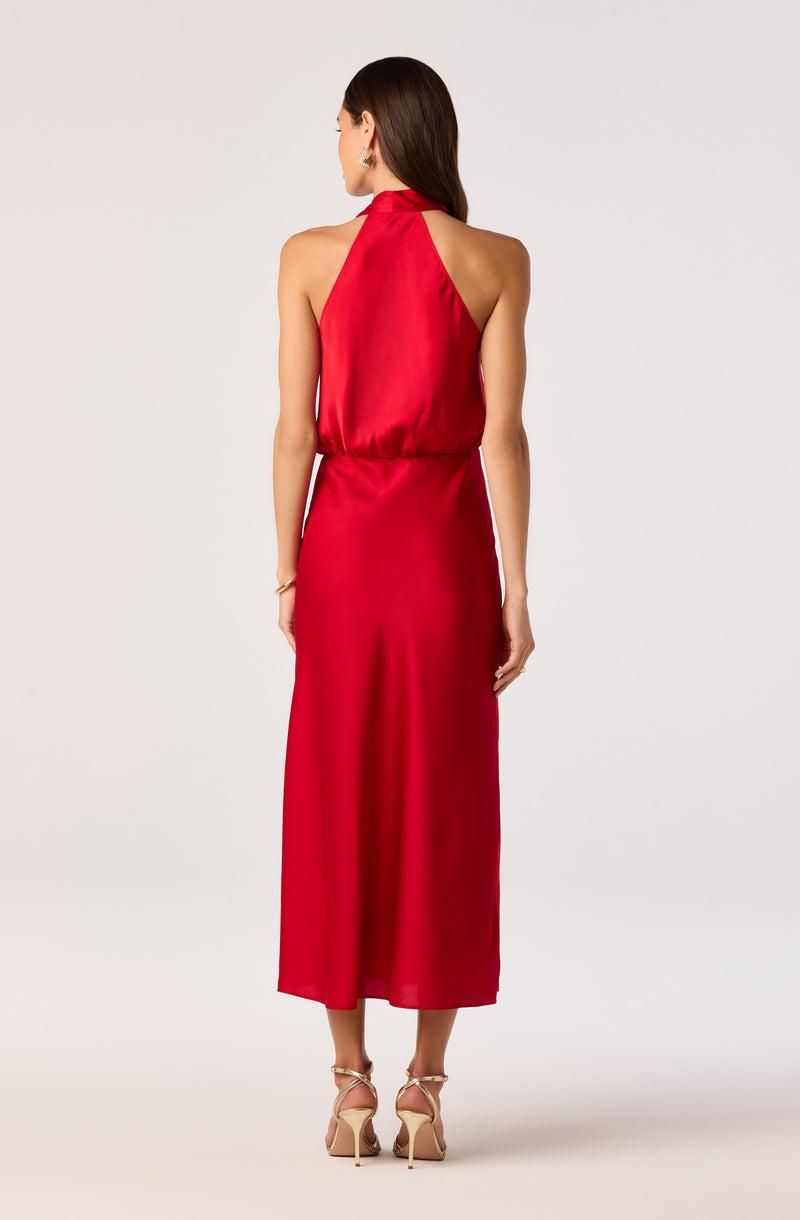 Back view of a woman in a red halter neck satin dress with a gathered waist, floor-length.