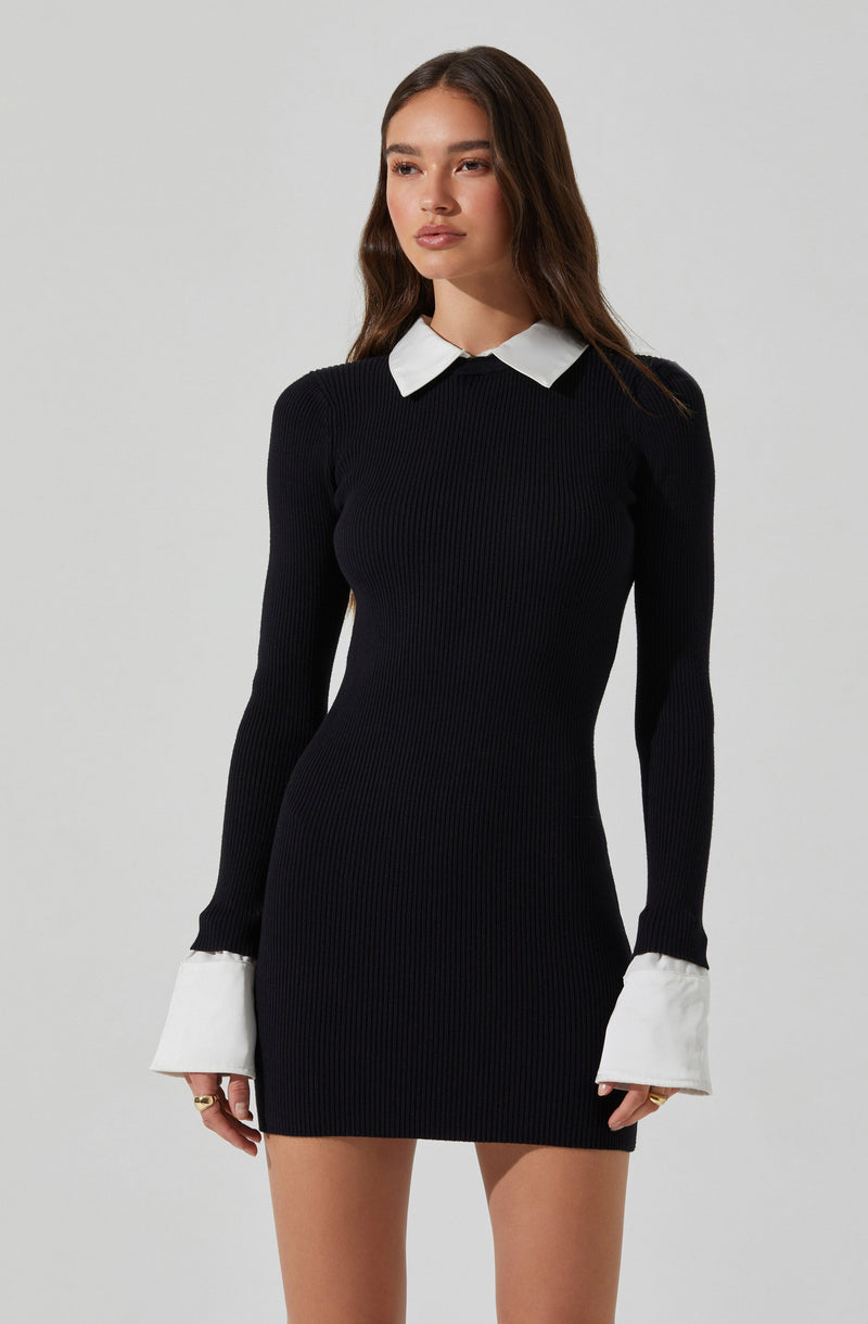 A young woman is wearing a fitted, long-sleeve, ribbed black dress with white collar and cuff accents.