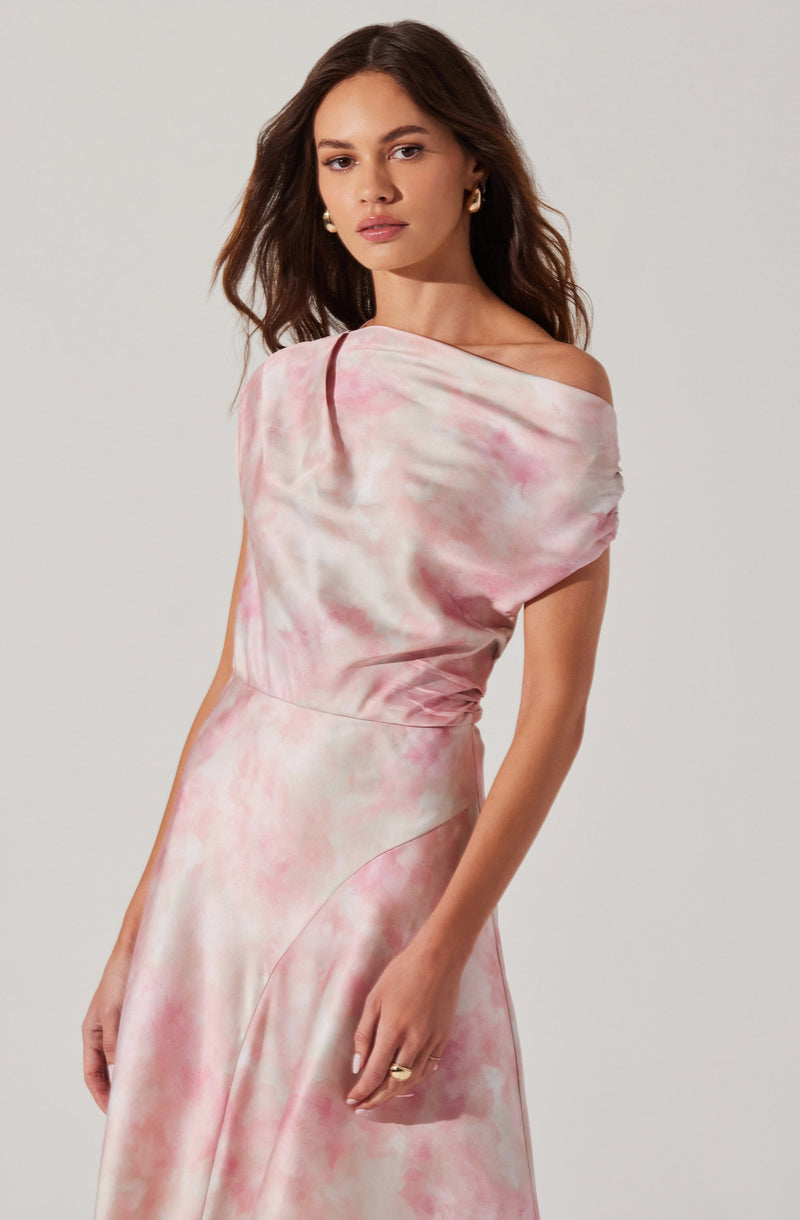 A woman is wearing a sleeveless, off-the-shoulder dress with a pink and white watercolor-like pattern. The fabric appears smooth and shiny, giving the dress an elegant appearance.