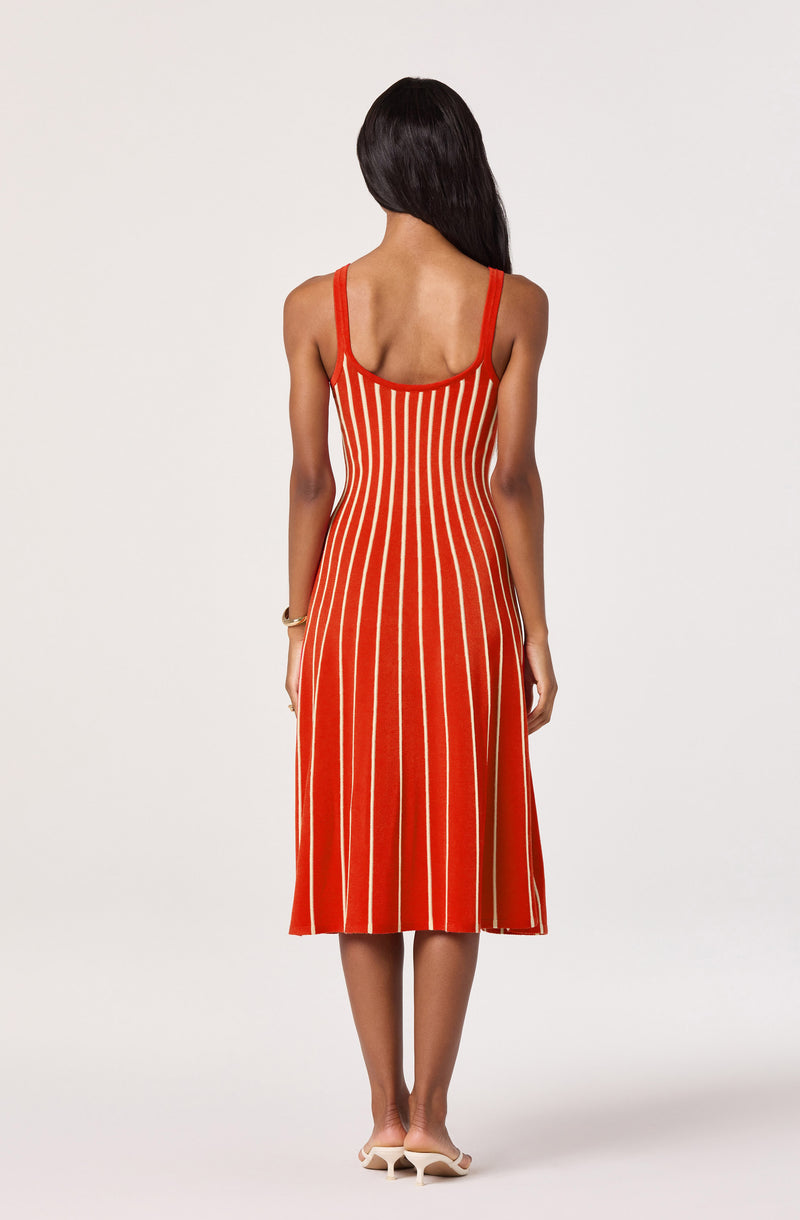 Red sleeveless dress with white vertical stripes, fitted at the waist and flaring at the bottom.