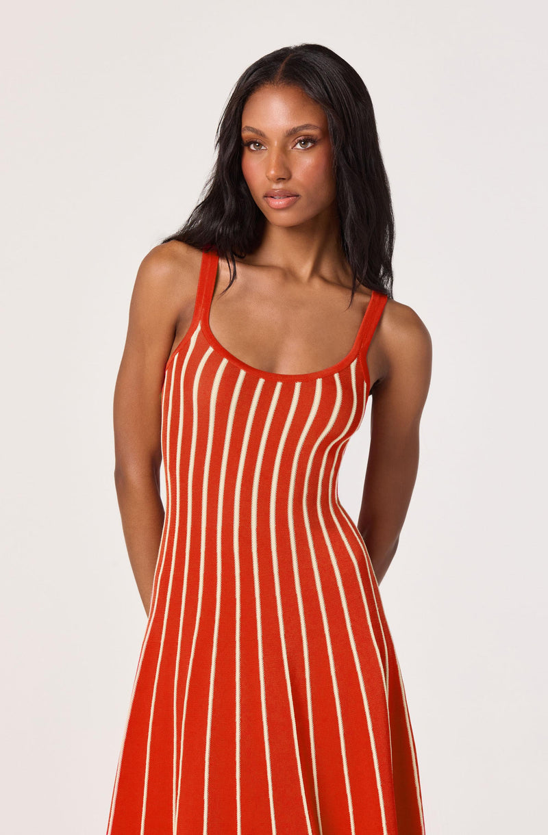 Woman wearing a red and white striped dress on a plain background