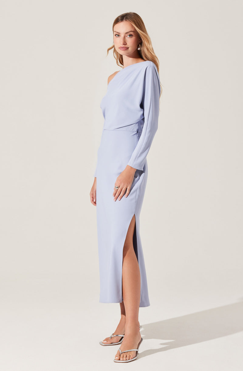 A woman is wearing a light blue, one-shoulder dress with long sleeves. The dress has a high slit on one side, revealing part of her leg. She is also wearing clear high-heeled sandals.