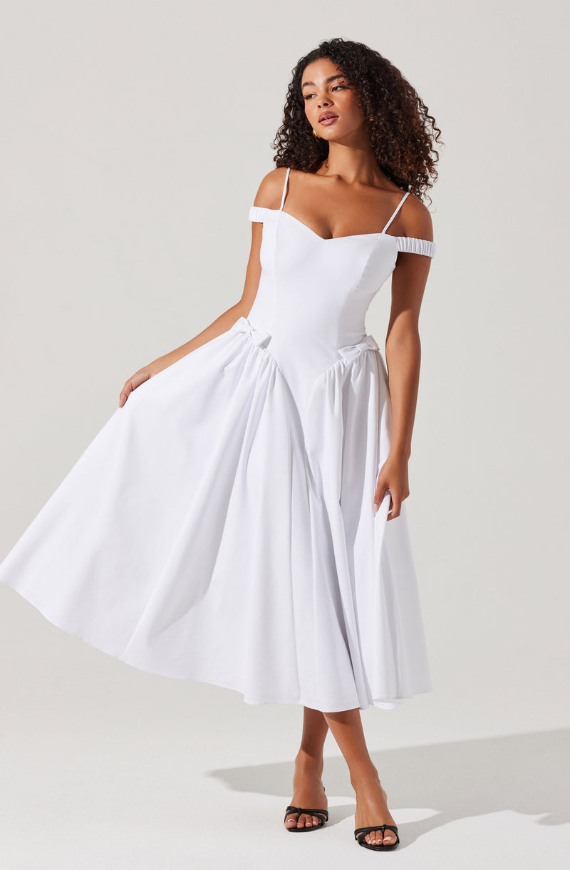 A woman is wearing a white dress with off-the-shoulder sleeves and thin spaghetti straps. The dress has a fitted bodice and a full, pleated skirt that extends to mid-calf length. The fabric appears lightweight and has a subtle sheen.