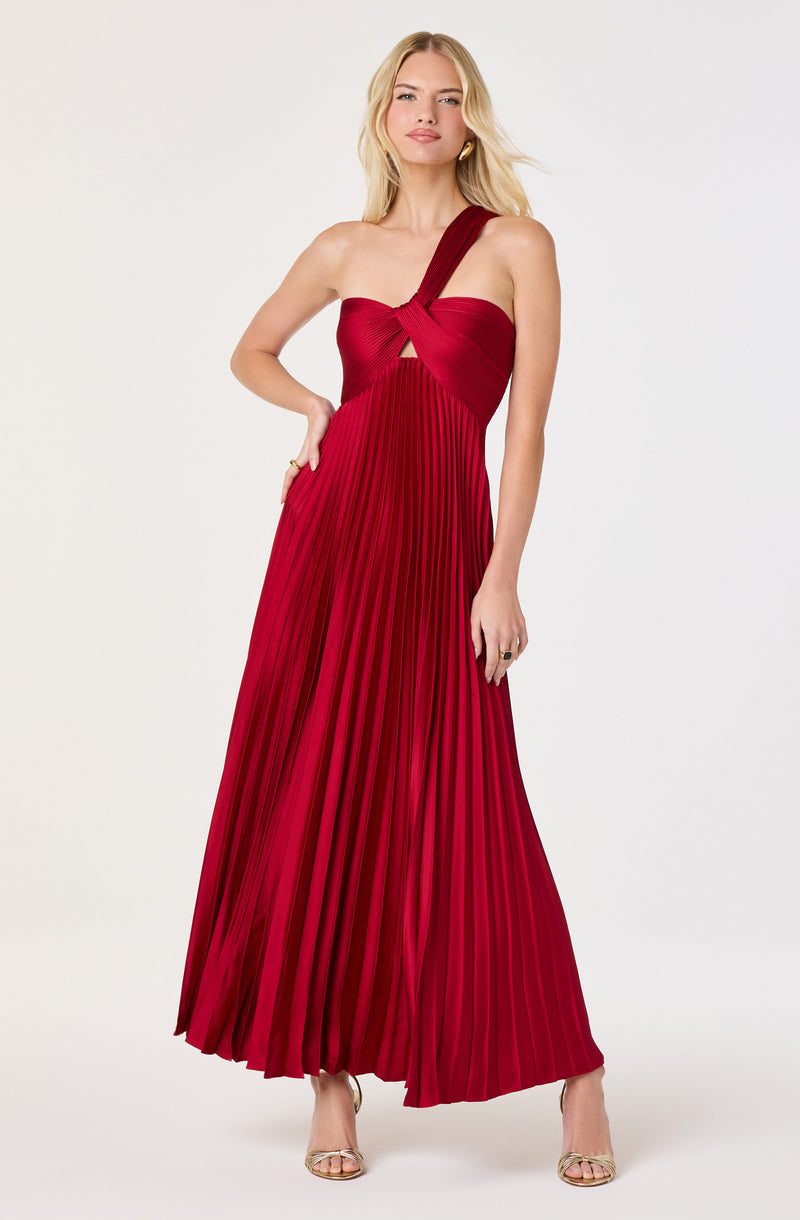 Women wearing a red pleated maxi dress with a twisted strap detail on one shoulder.