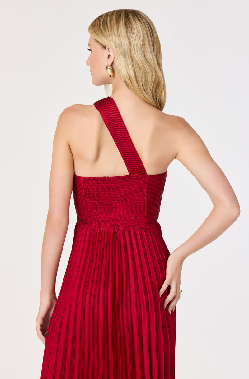Red pleated dress with a single wide strap over the shoulder, fitted bodice.