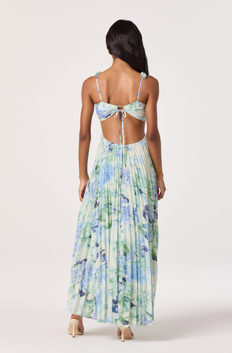 Woman in a flowy, floral maxi dress with a cutout back and spaghetti straps.