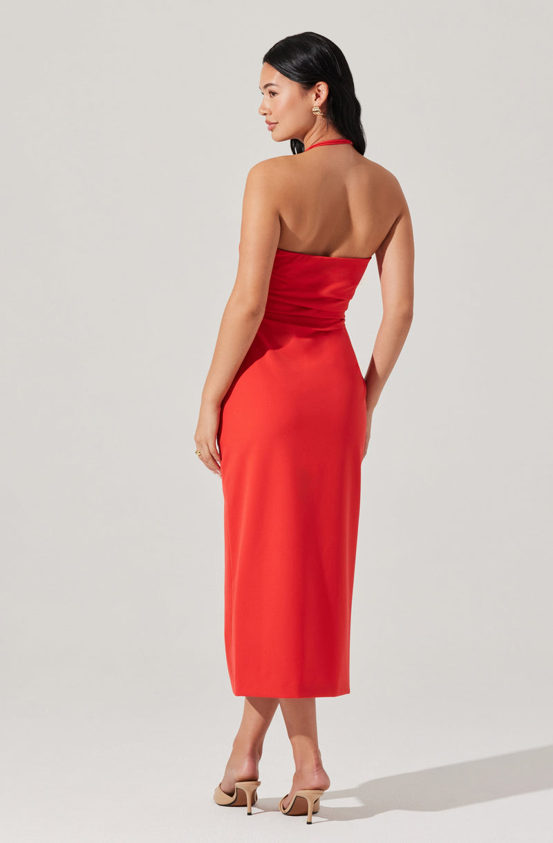 A woman is wearing a strapless, fitted red dress that extends to mid-calf length. The dress is smooth and elegant, with a slight sheen. She is also wearing nude-colored high heels.