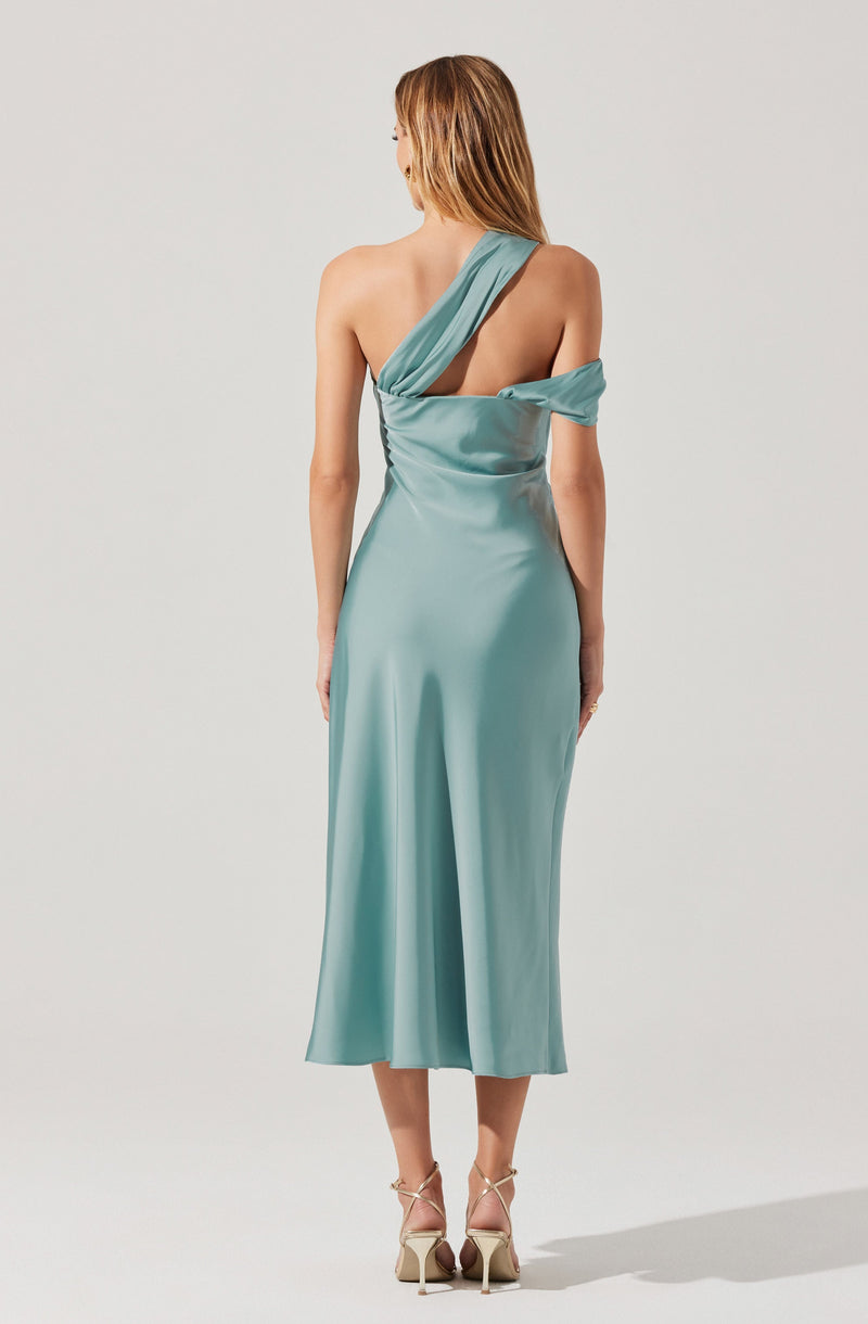 A woman is wearing a satin, light teal, one-shoulder dress with a draped design. The dress features an asymmetrical neckline with a wide strap on one shoulder and a loose fabric detail on the opposite side. The length of the dress reaches mid-calf. She is also wearing beige high-heeled sandals with thin straps.