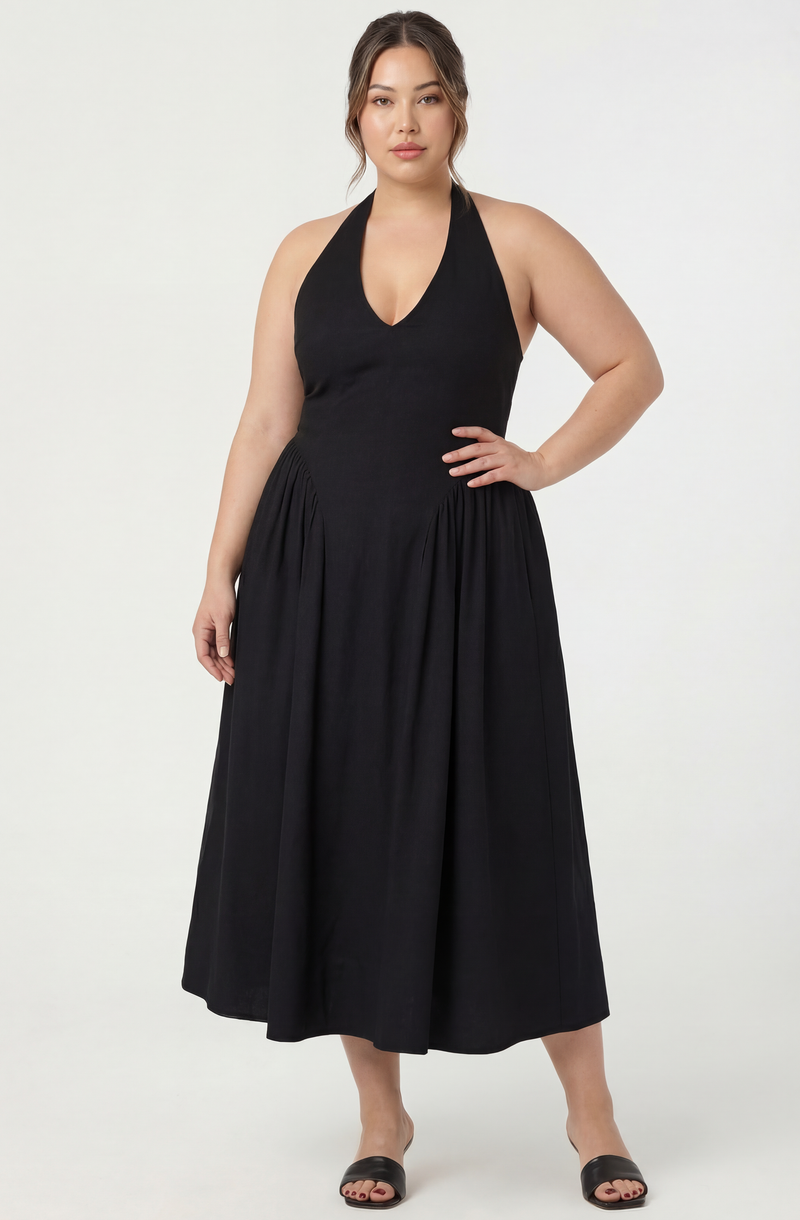 Woman in a sleeveless black halter dress with a V neckline and full, gathered skirt.