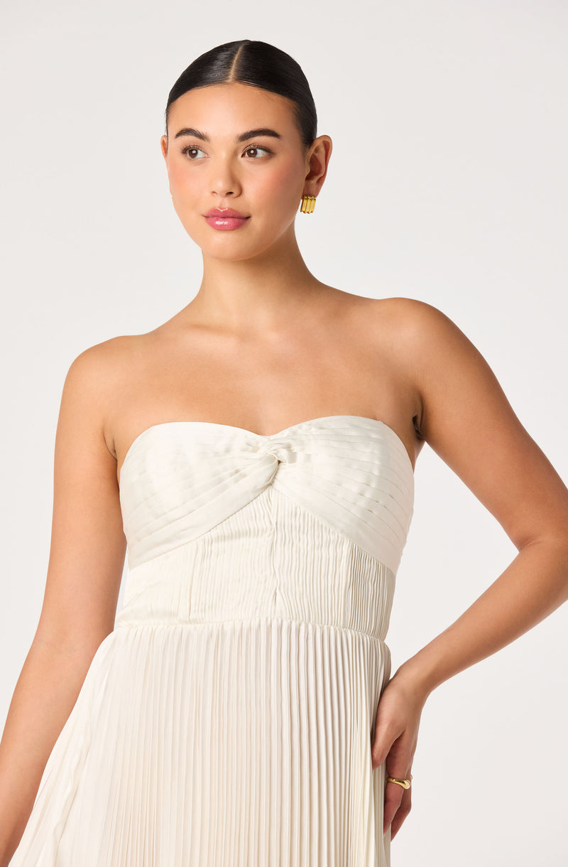 Woman in a strapless white pleated dress.