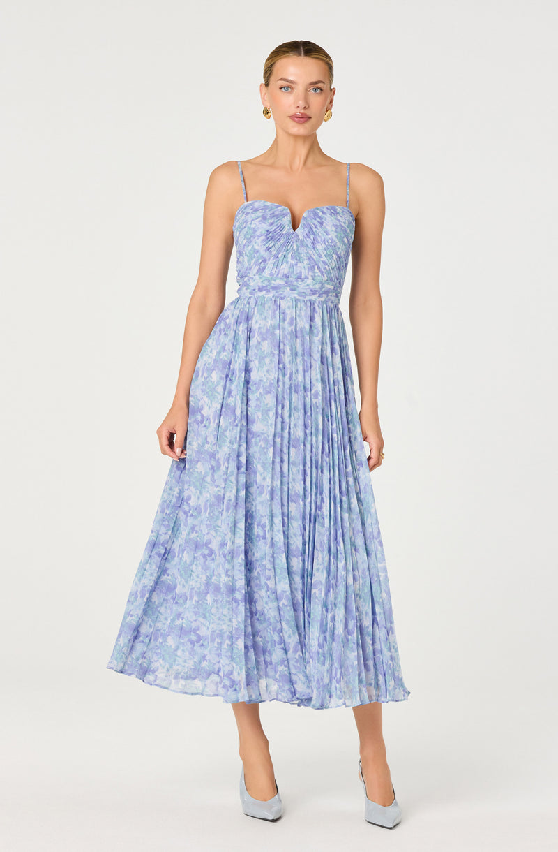 Woman wearing a lavender and blue tie-dye maxi dress with a sweetheart neckline and thin straps.