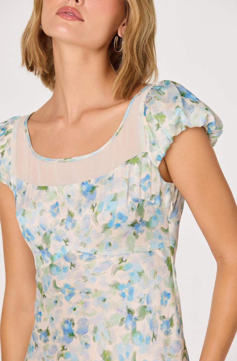 Light floral dress with puffed, short sleeves, and a sheer, rounded yoke at the neckline.