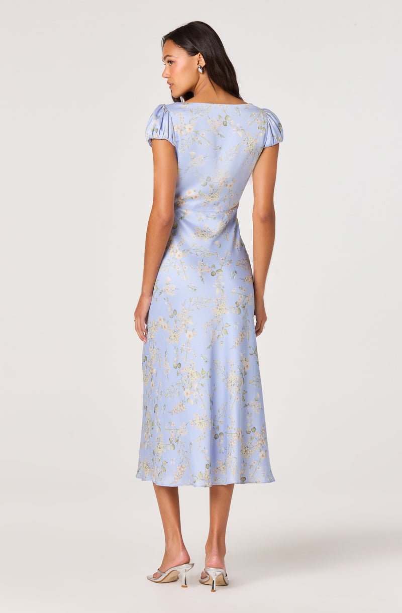 Light blue dress with puffed short sleeves and gold floral pattern.