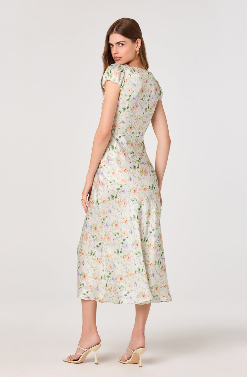 Light-colored floral midi dress with puffed short sleeves and a fitted waist.