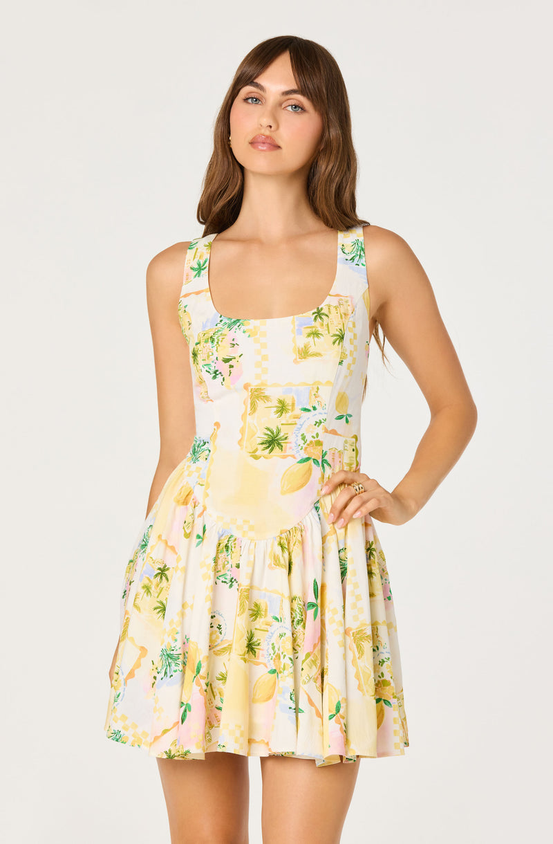 Woman in sleeveless, knee-length dress with a tropical, pastel-colored pattern.