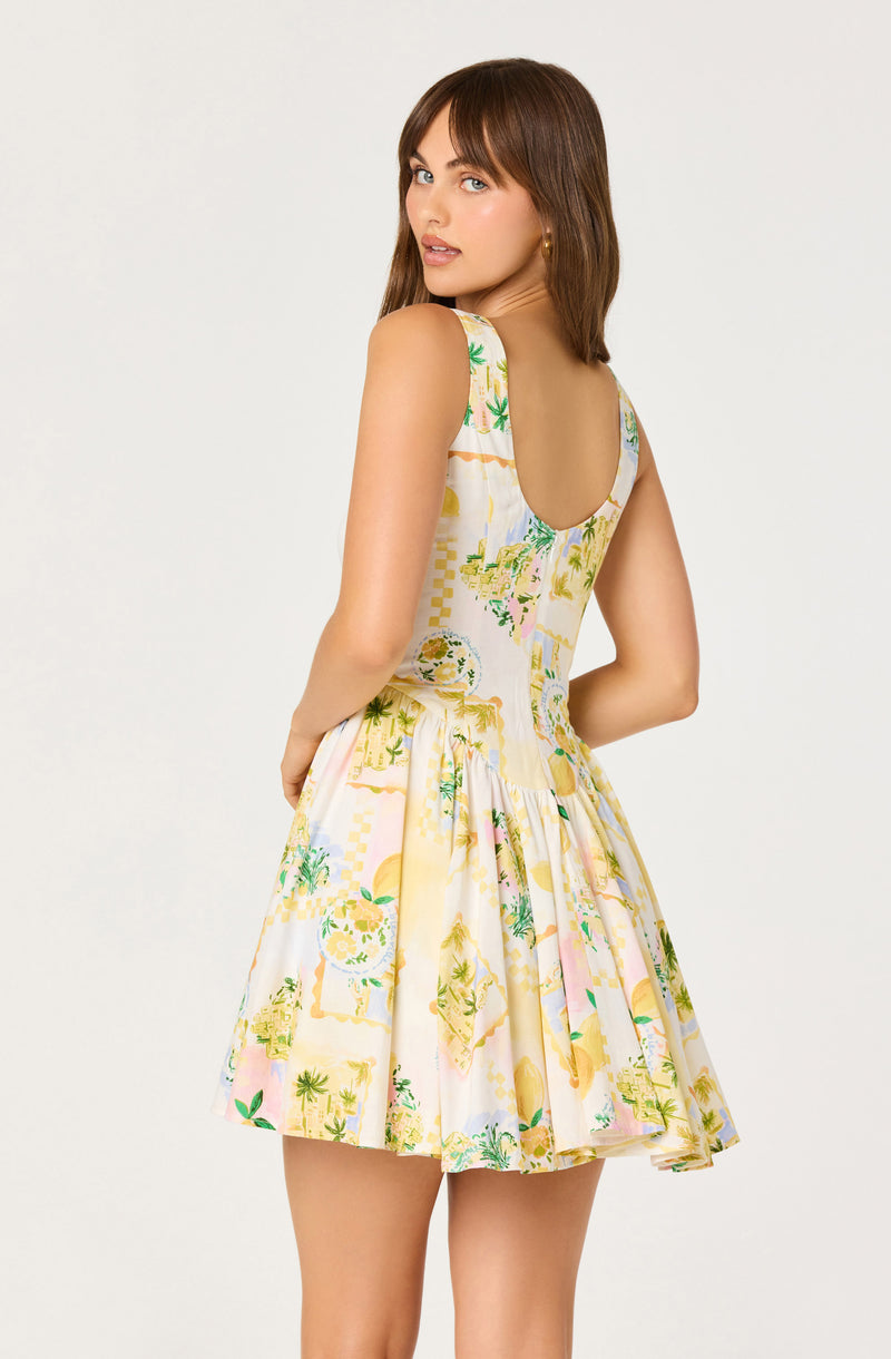 Woman in a sleeveless dress with a colorful, tropical print and a fit-and-flare silhouette.