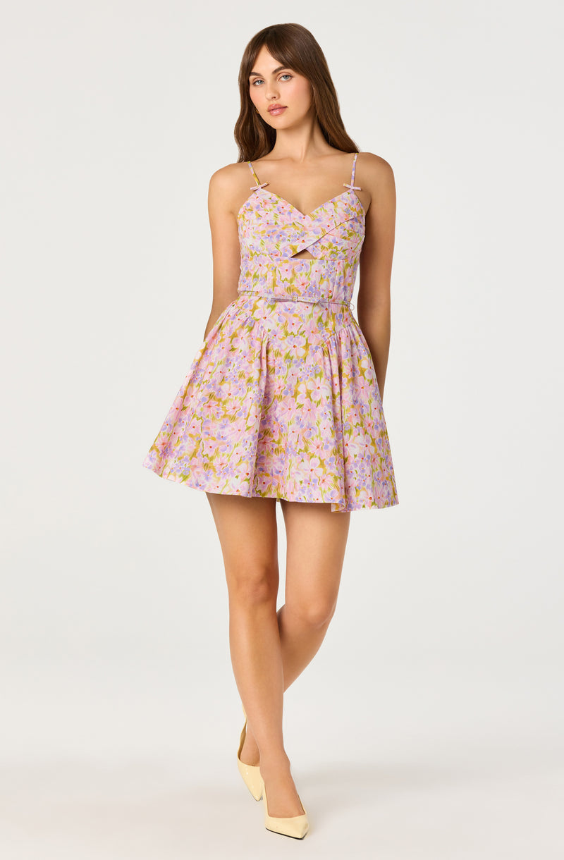 Girl in a pastel floral dress with spaghetti straps, cutout detail, and a flared skirt.