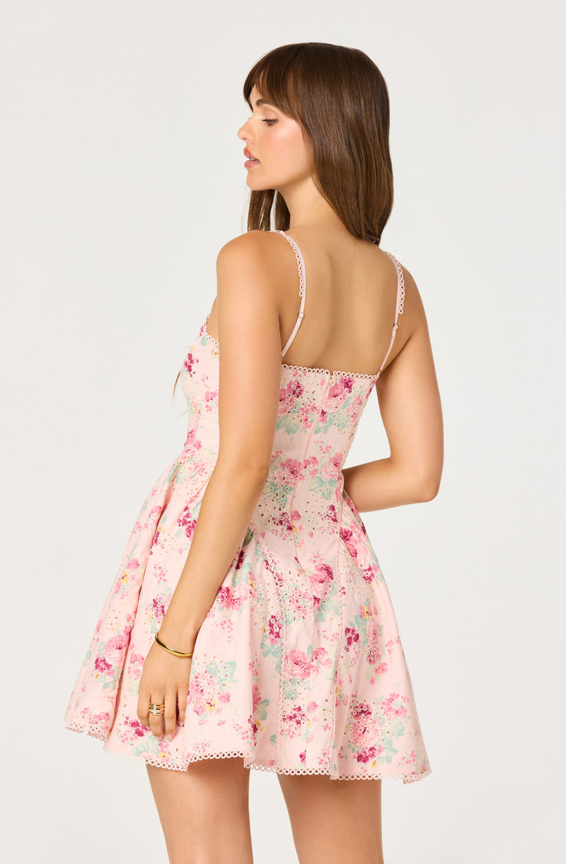 Woman in a pink floral slip dress with spaghetti straps and lace trim.