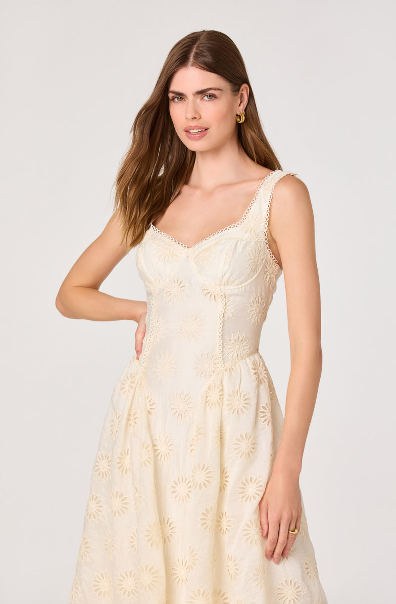 Cream sleeveless dress with embroidered floral pattern and lace trim details.