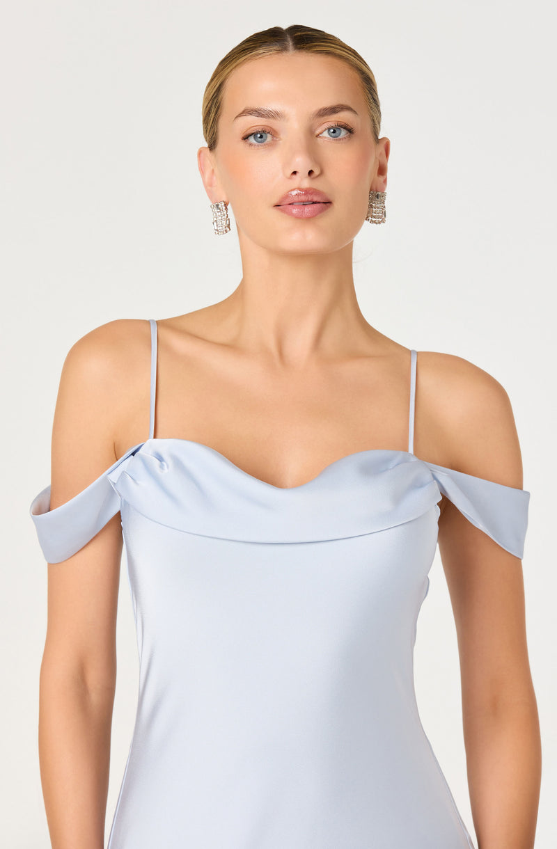 Woman in light blue satin dress with off-shoulder ruffle sleeves and thin spaghetti straps.