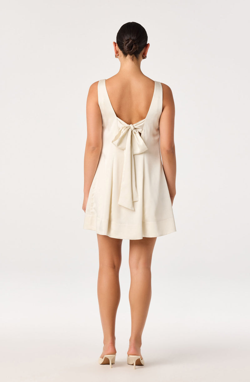Cream sleeveless dress with a large bow at the back.