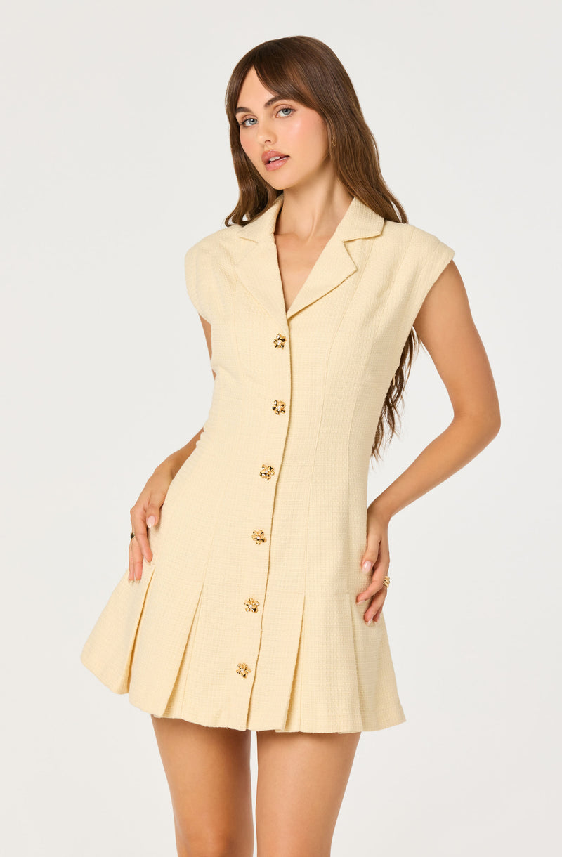 Cream sleeveless dress with gold floral buttons and a pleated skirt.