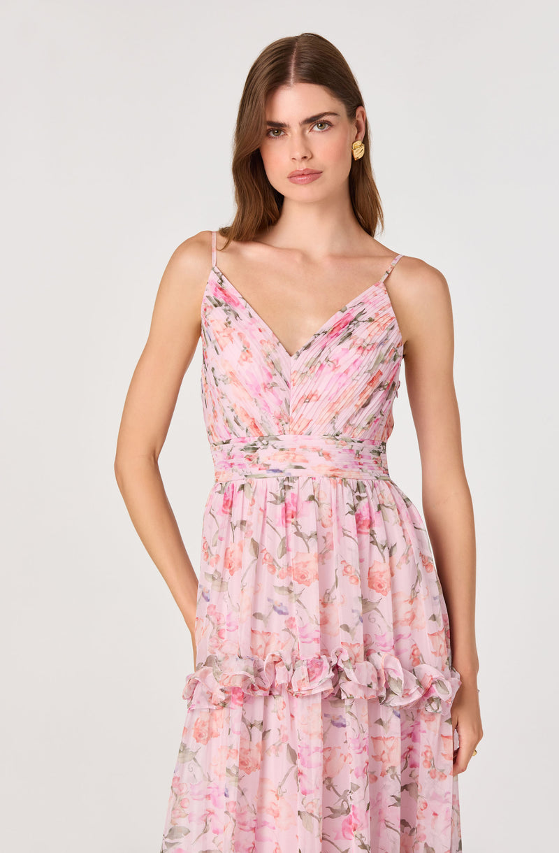 Woman wearing a pink floral spaghetti strap dress with ruffle hem and layered skirt.