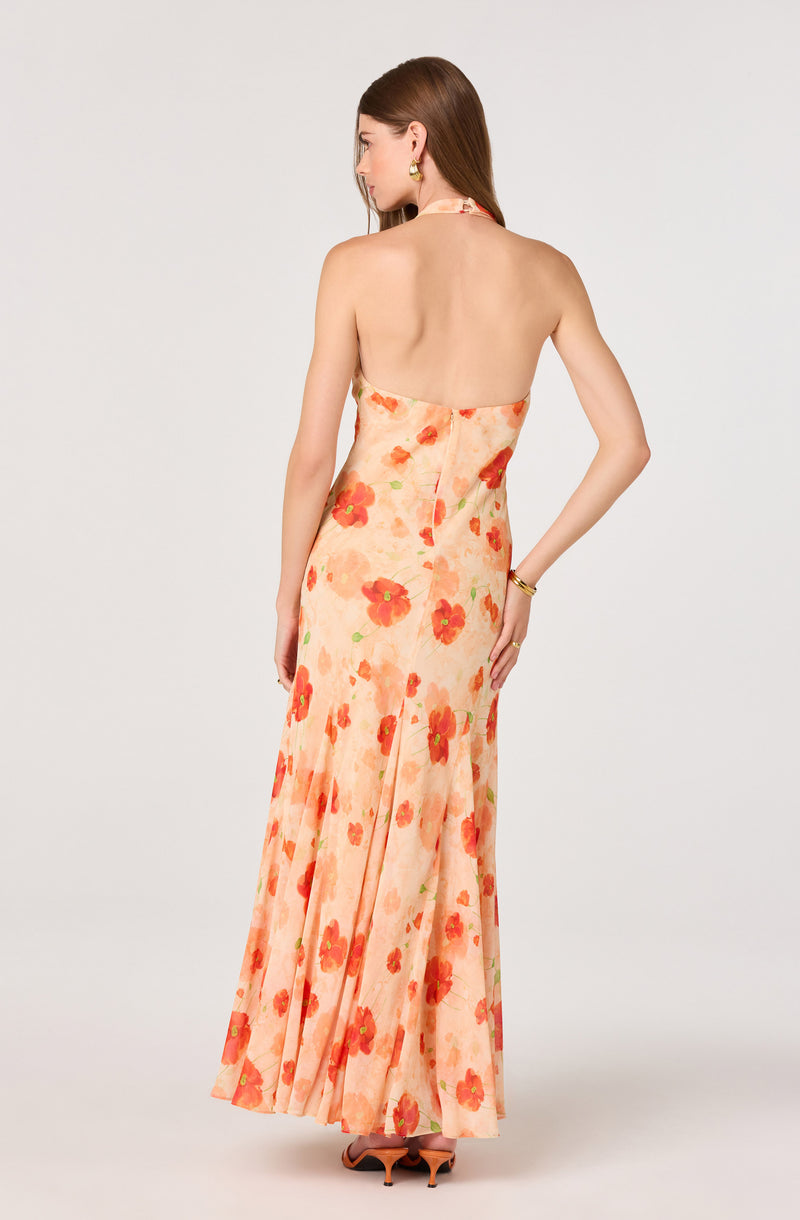Woman wearing a strapless, floral peach and red maxi dress.