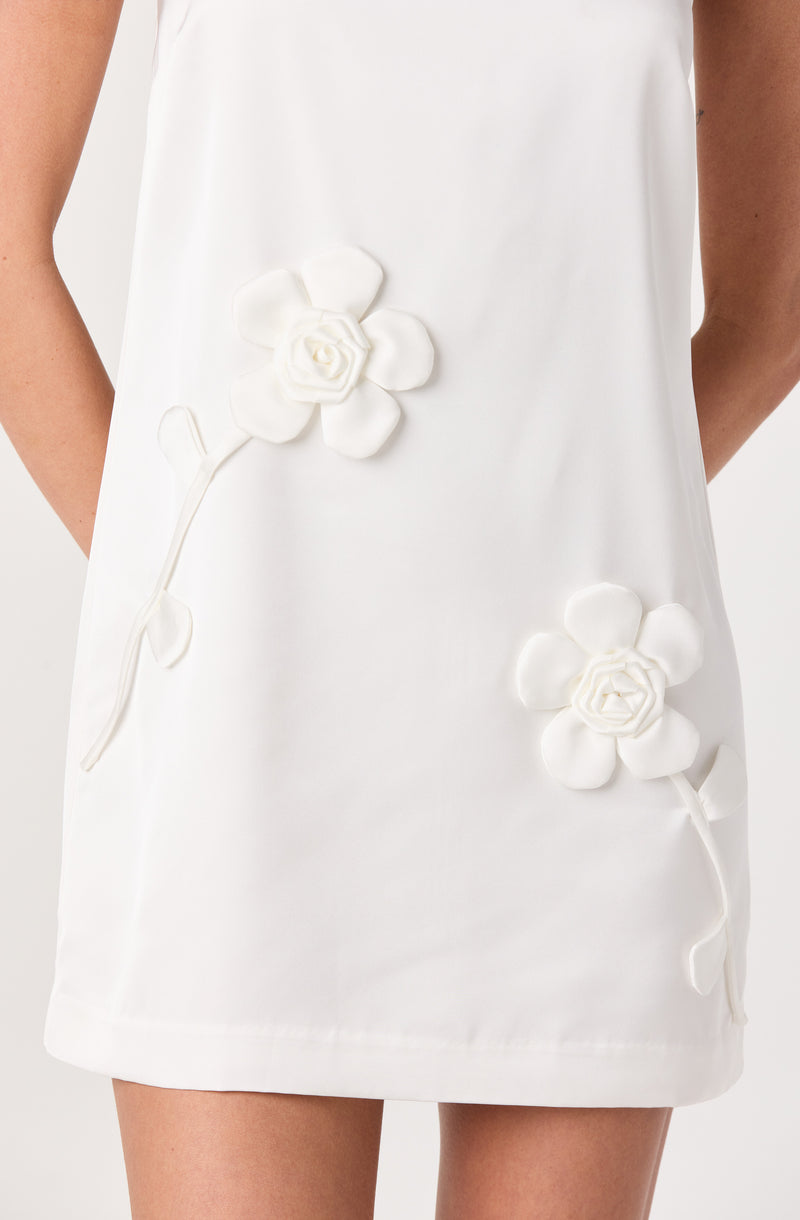 White dress with 3D floral applique details on the front.