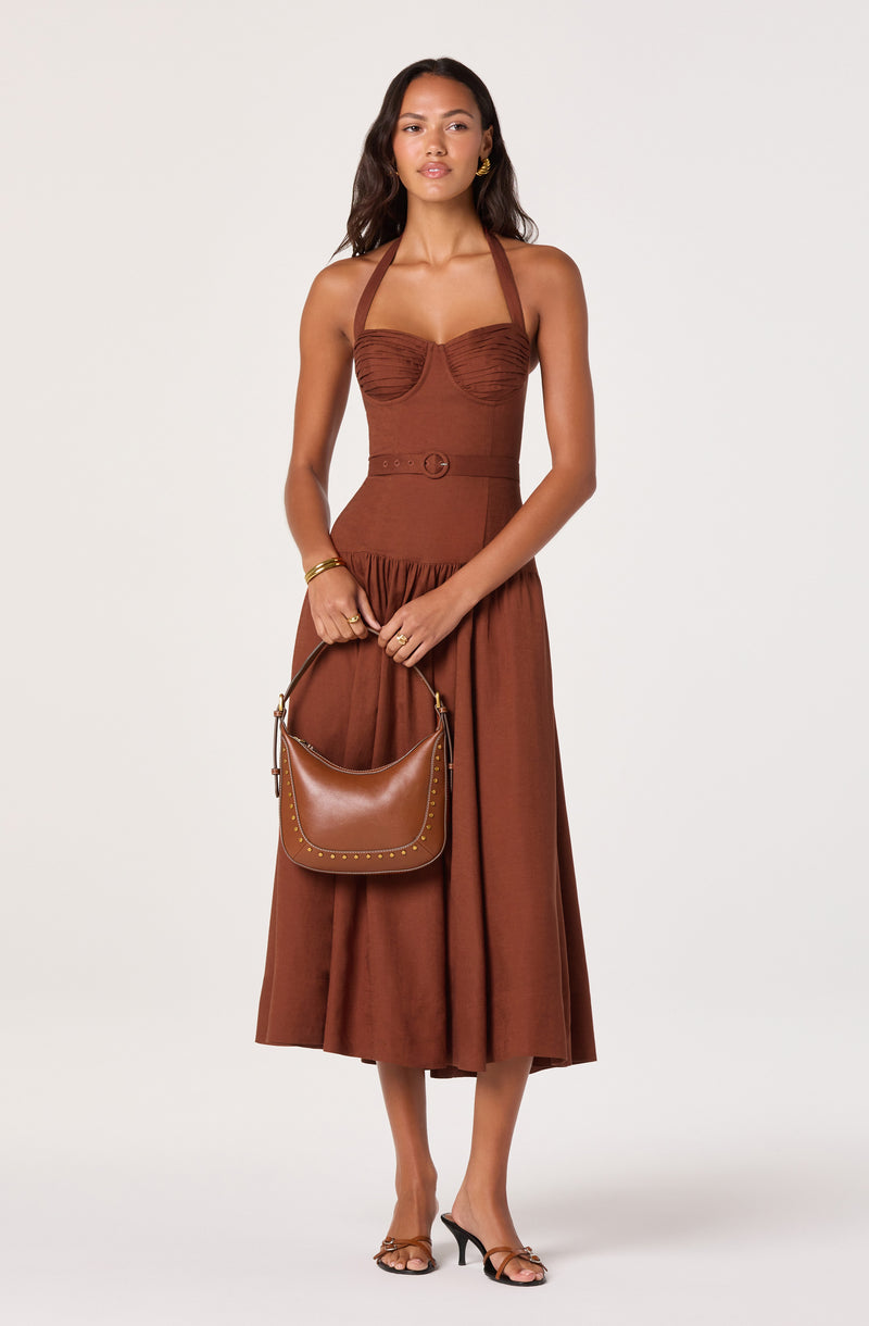 Brown halter top and high-waisted midi skirt, with a matching brown handbag and open-toed heels.