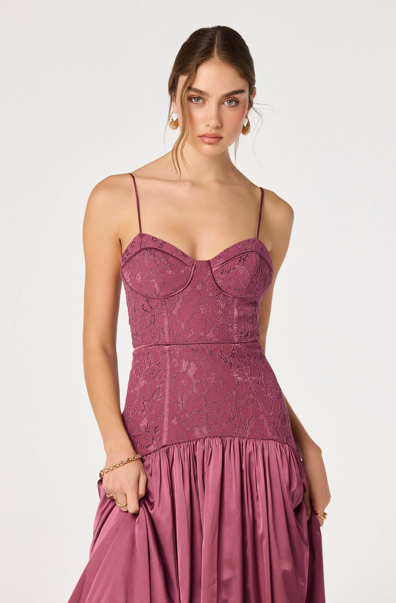 Woman wearing a pink strapless lace top with thin spaghetti straps and a pink satin skirt with pleats.