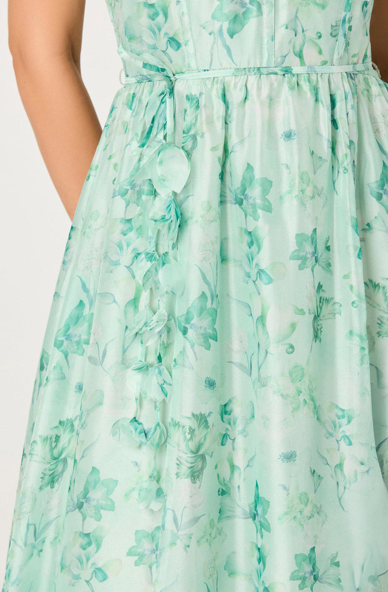 Light green floral dress with a fitted waist and tied bow detail on the side.