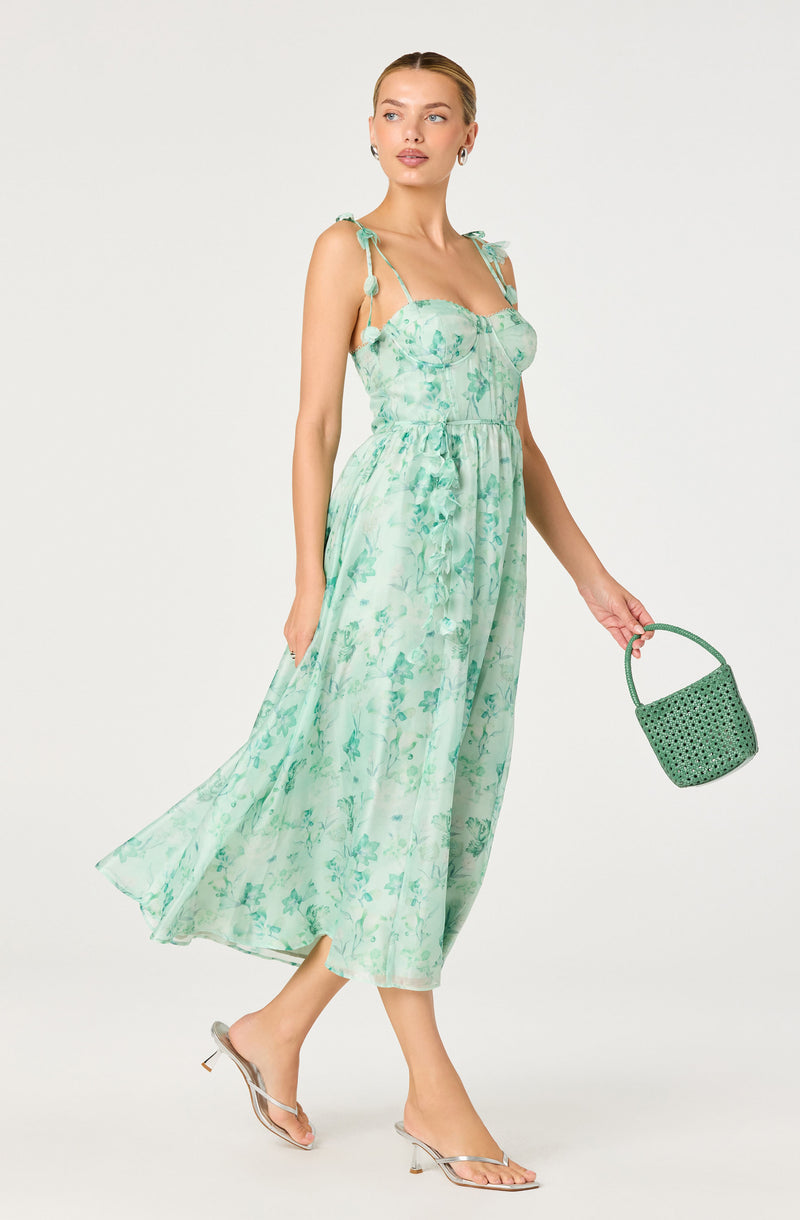 Light green floral sleeveless dress with tied shoulder straps and a flowy, ankle-length skirt.