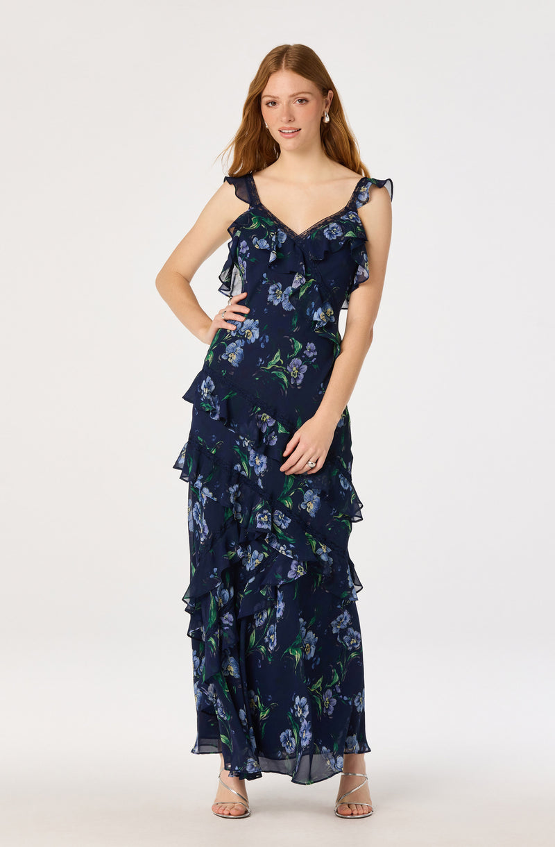 Woman wearing a navy blue floral ruffled dress with thin straps and a V-neck.