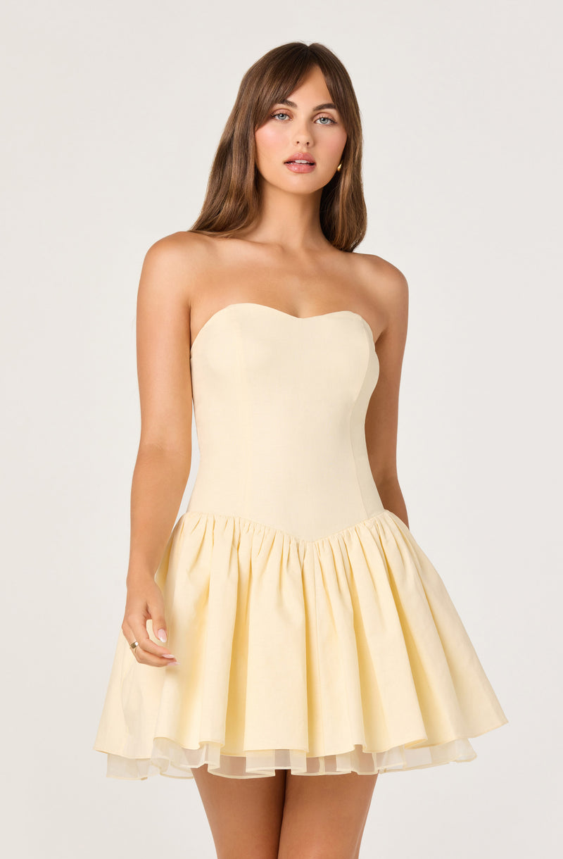 Cream strapless dress with fitted bodice and flared ruffled skirt.