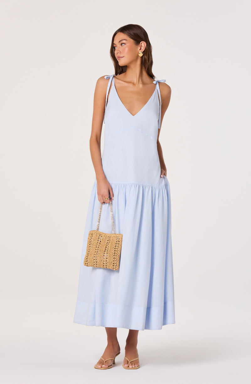 Light blue sleeveless maxi dress with shoulder tie straps and a gathered lower hem.